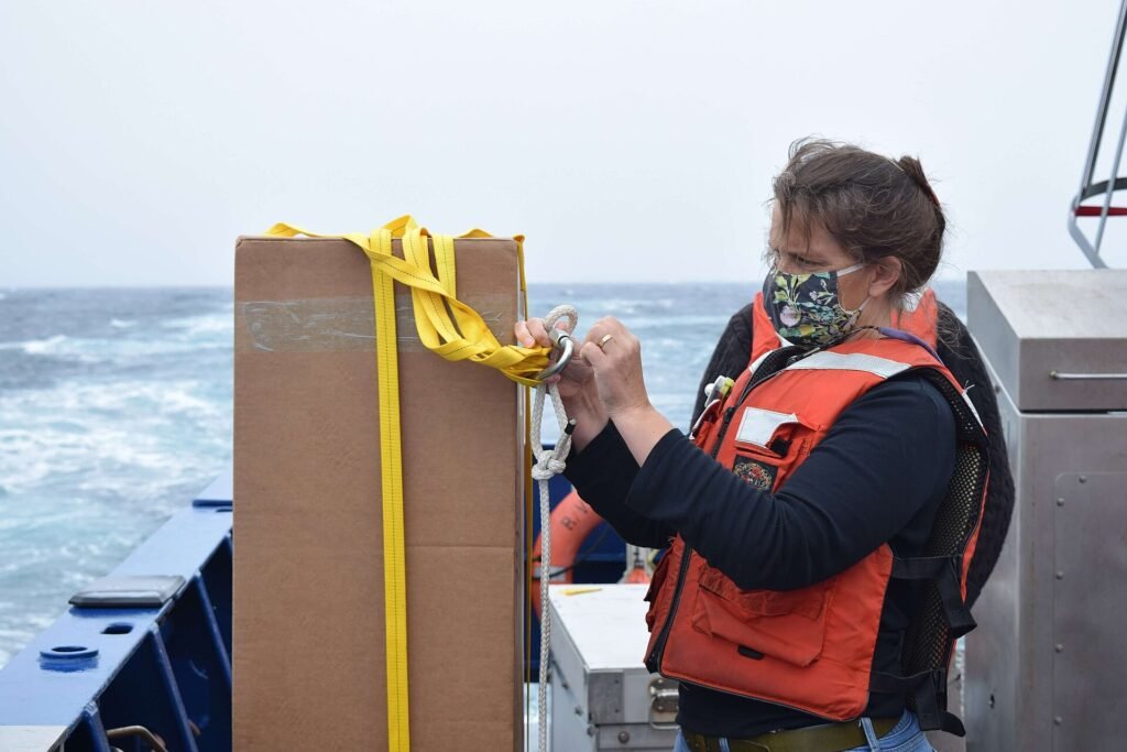 A researcher prepares an Argo float, one of thousands of robotic instruments that measure ocean temperature and salinity.